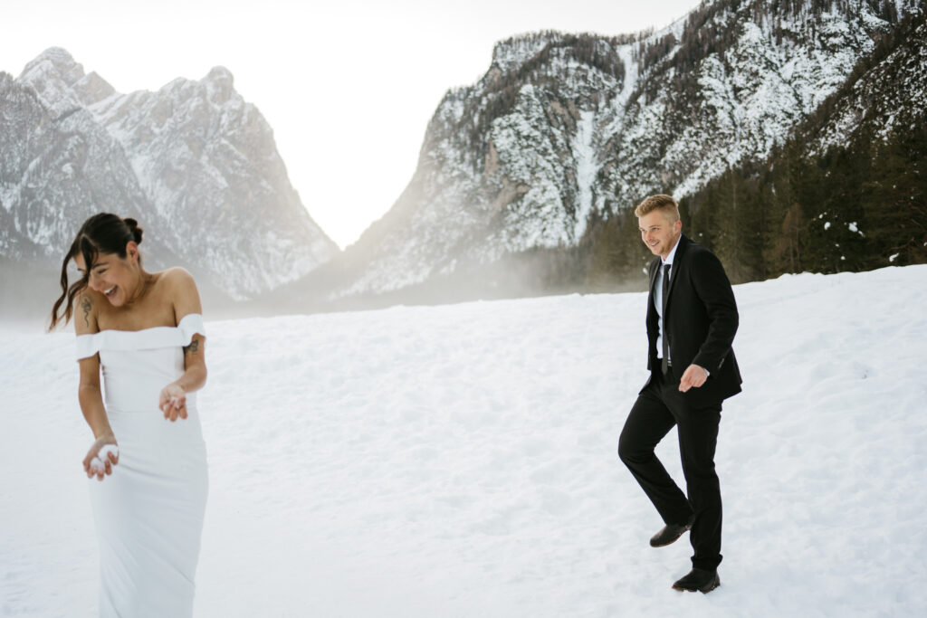 Couple playing in snowy mountain landscape