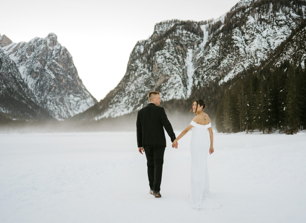 Couple walking in snow with mountains background