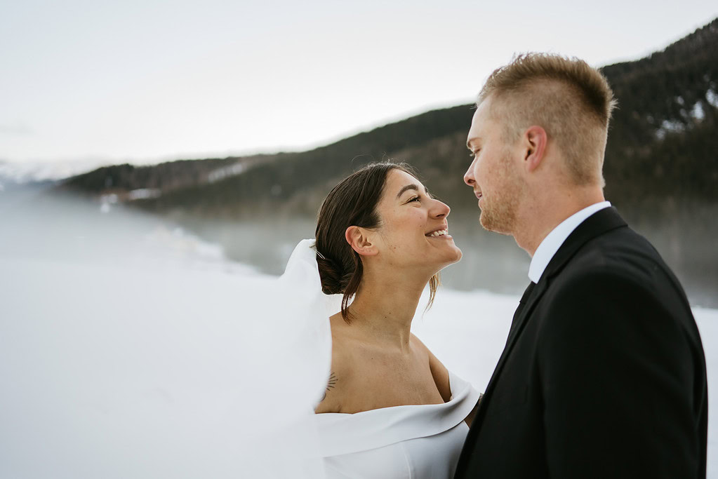 Couple smiling in snowy, mountainous landscape