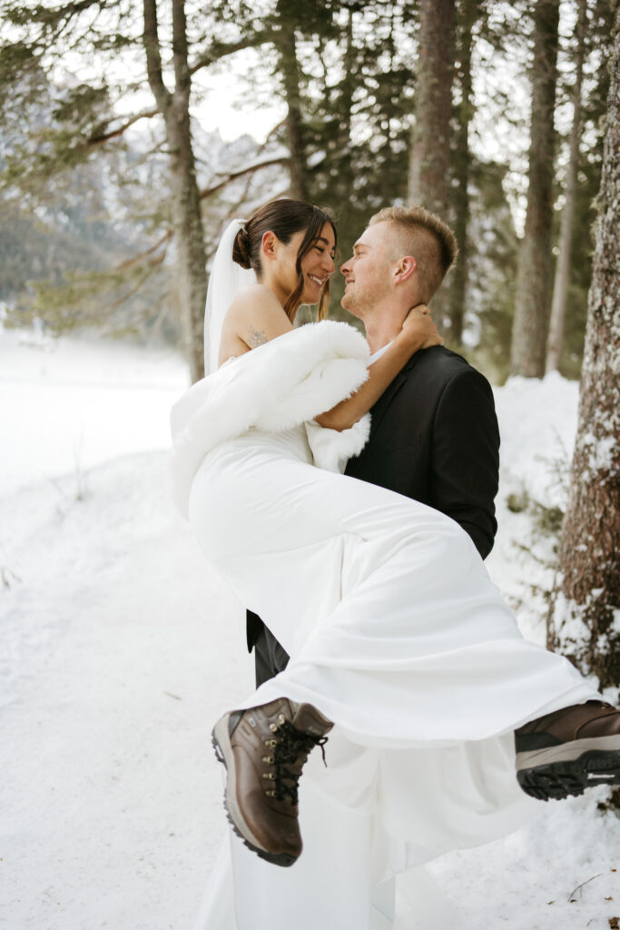 Wedding couple embracing in snowy forest