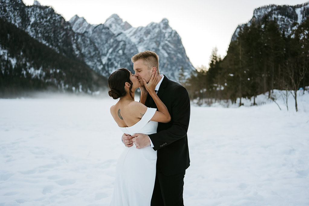 Couple kissing in snowy mountain landscape