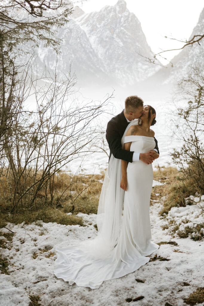 Couple kissing in snowy mountain landscape