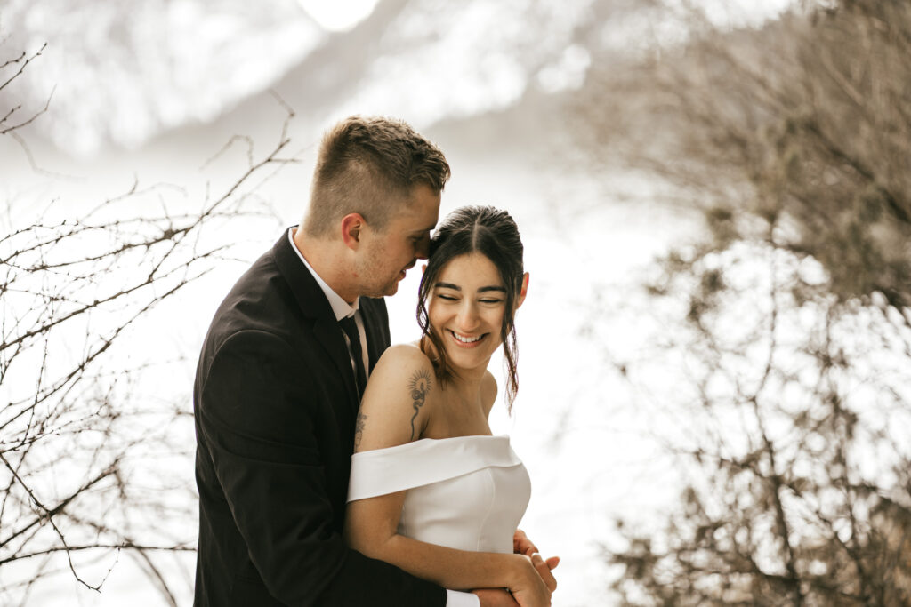 Couple embracing outdoors, smiling in snowy setting