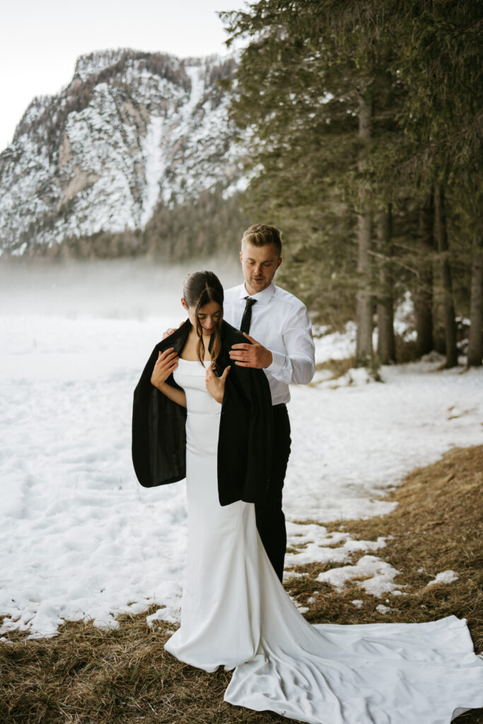 Couple in snow with mountain backdrop.