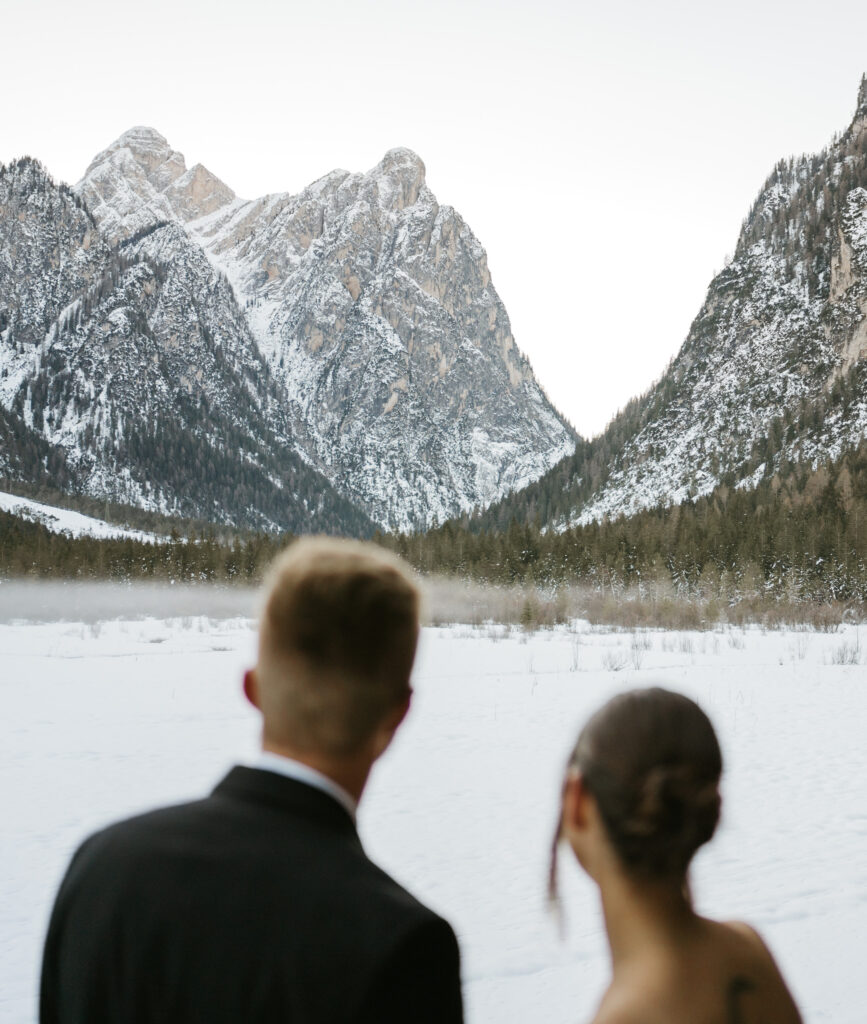 Couple viewing snowy mountains and landscape.