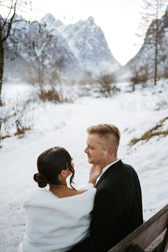 Couple seated in snowy mountain landscape.