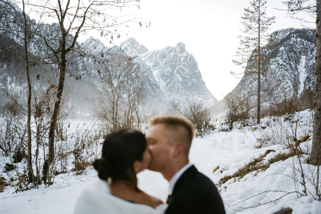 Couple kissing in snowy mountain landscape