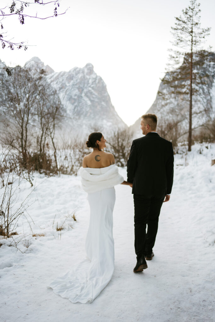 Bride and groom walking in snow-covered path