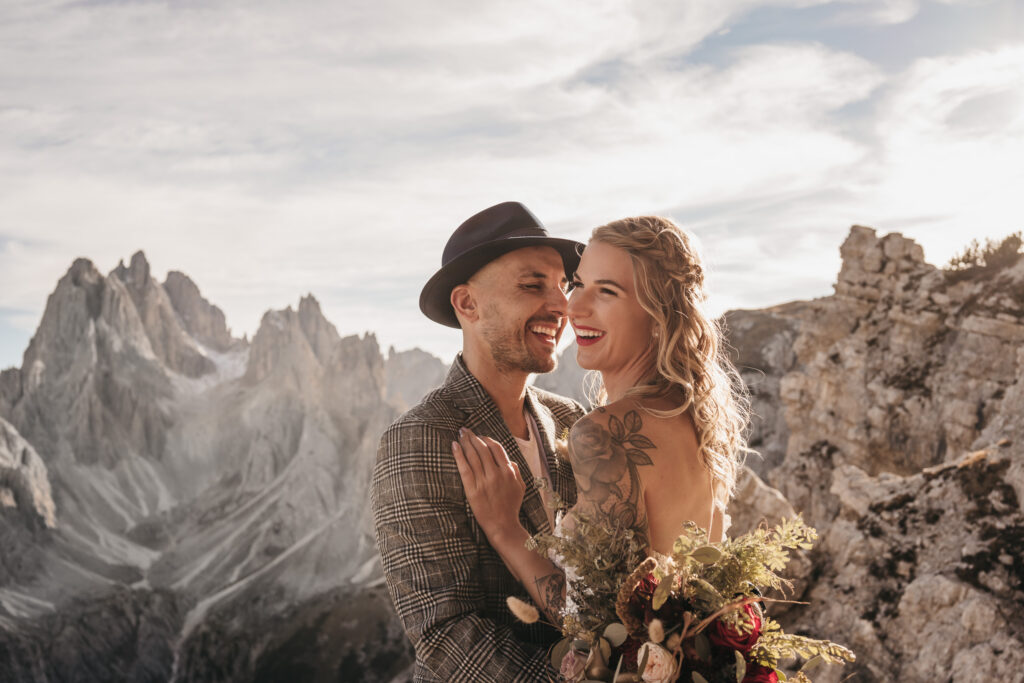 Couple smiling in mountain landscape.