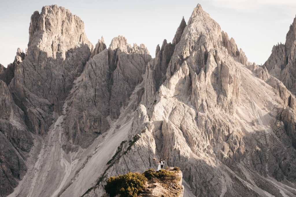 Couple standing on rocky mountain cliff