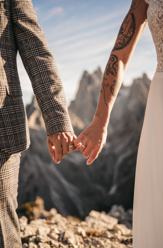 Couple holding hands on a mountain backdrop.