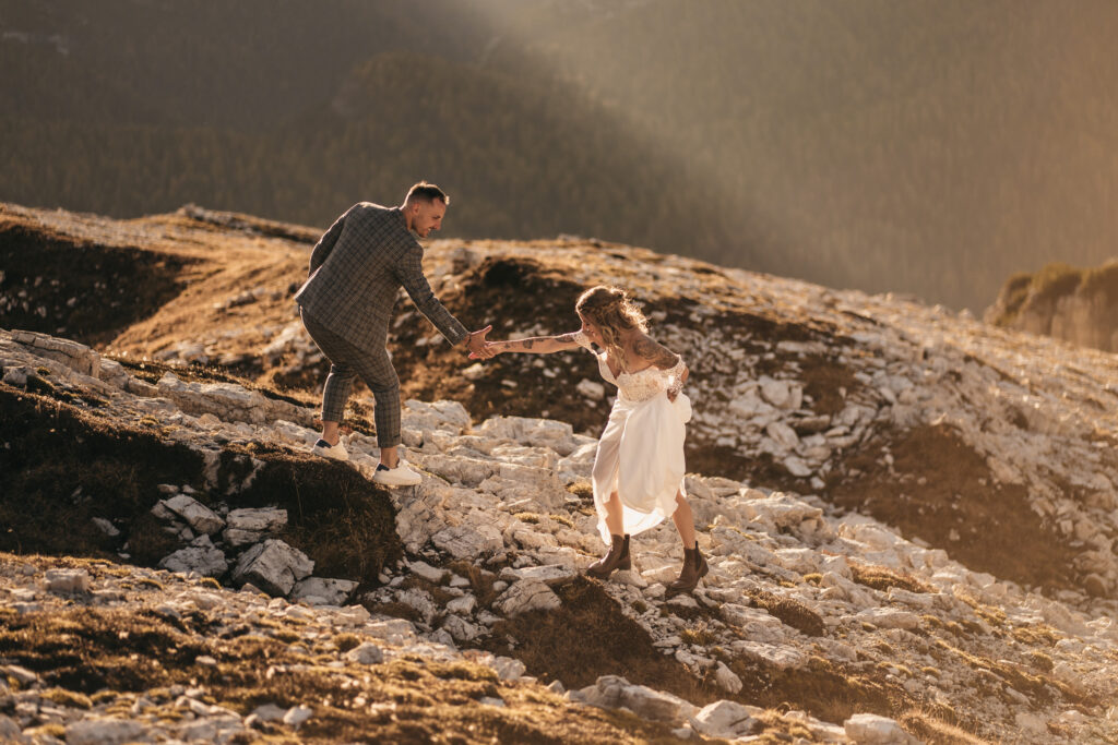 Couple hiking on rocky terrain during sunset