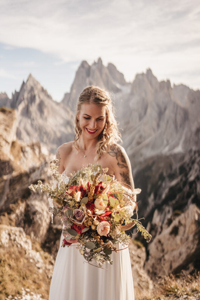 Bride with bouquet in scenic mountain landscape