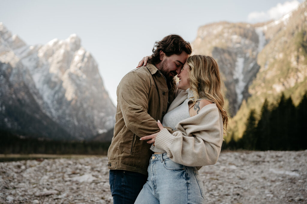 Couple embracing with mountains in background.