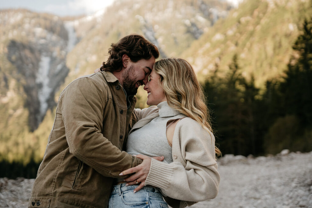 Couple embraces in scenic mountain setting.