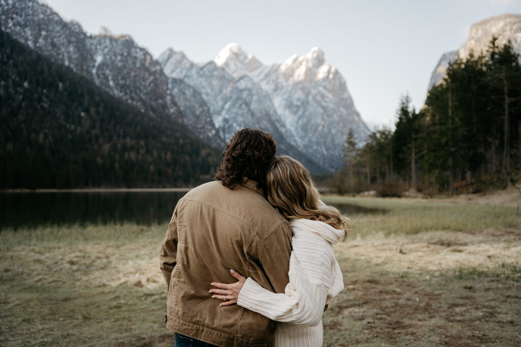 Couple embracing by lake with mountain view