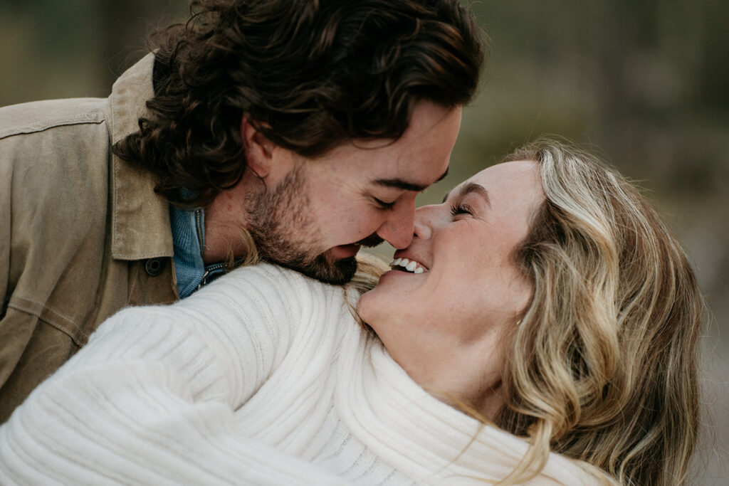 Couple smiling and embracing outdoors.