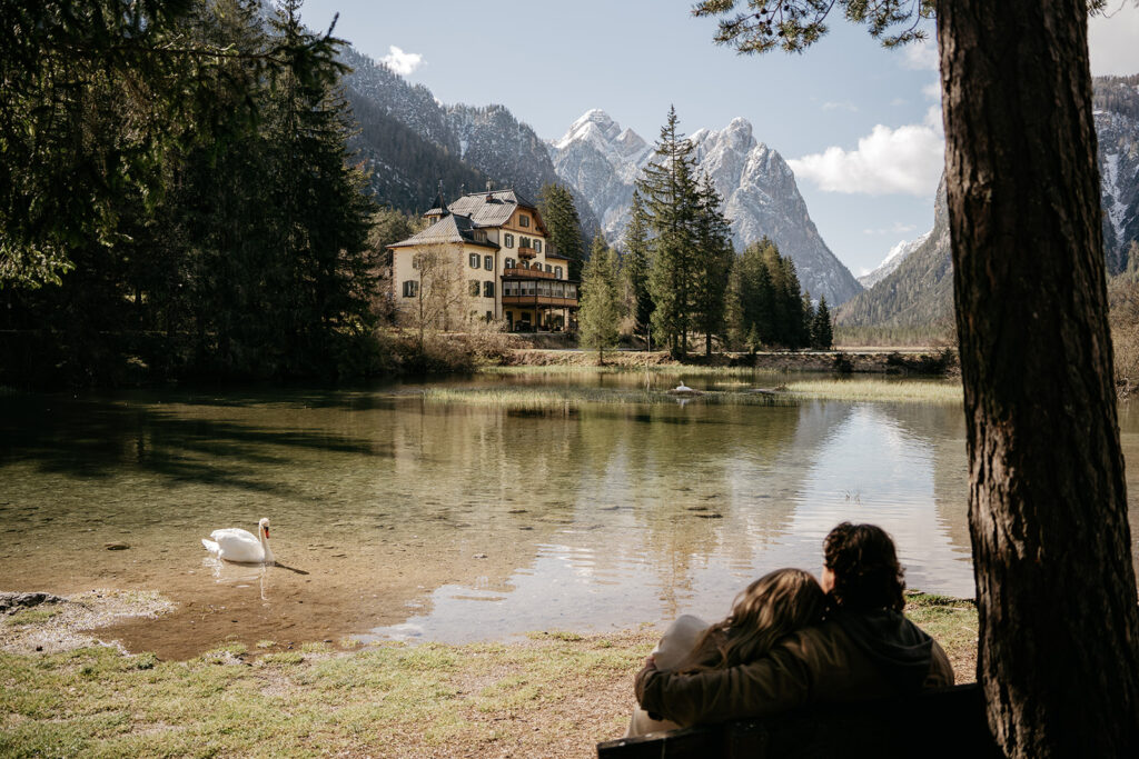 Couple gazing at serene lake and mountains.