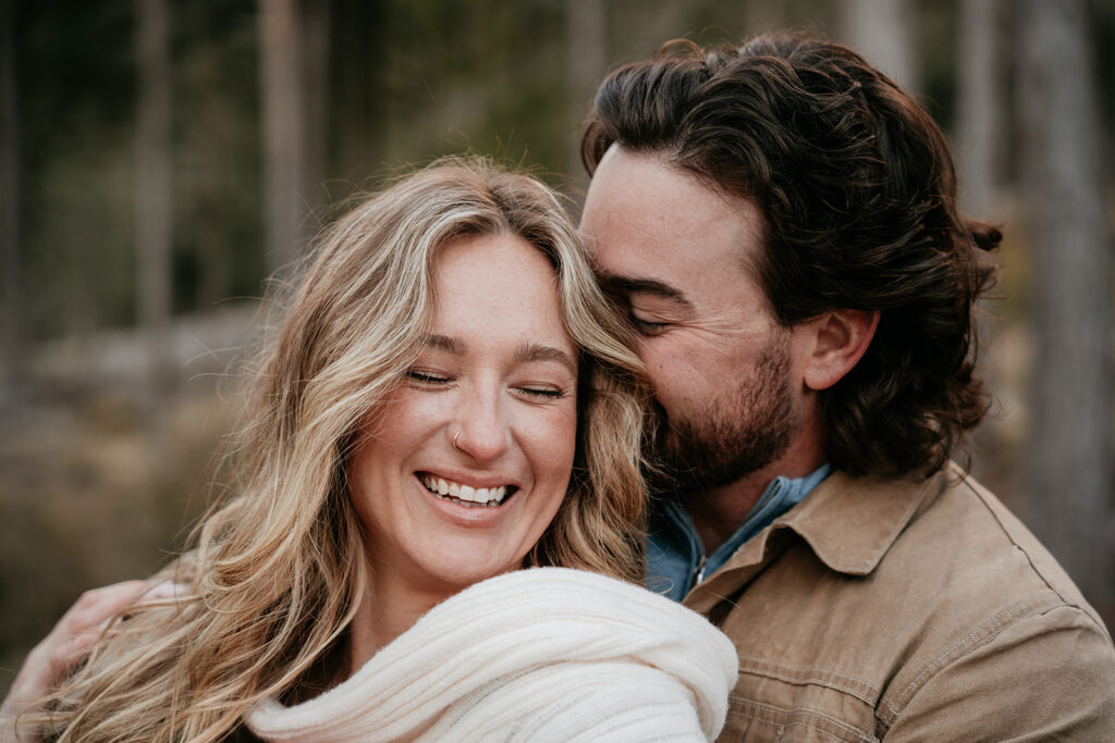 Happy couple embracing outdoors, smiling warmly.