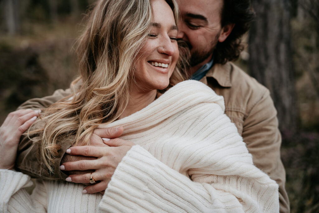 Couple embracing outdoors, smiling warmly