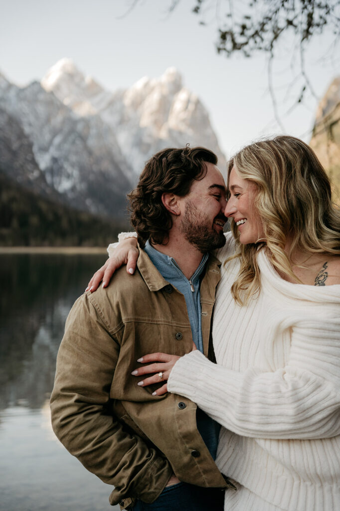 Couple embracing by a mountain lake.