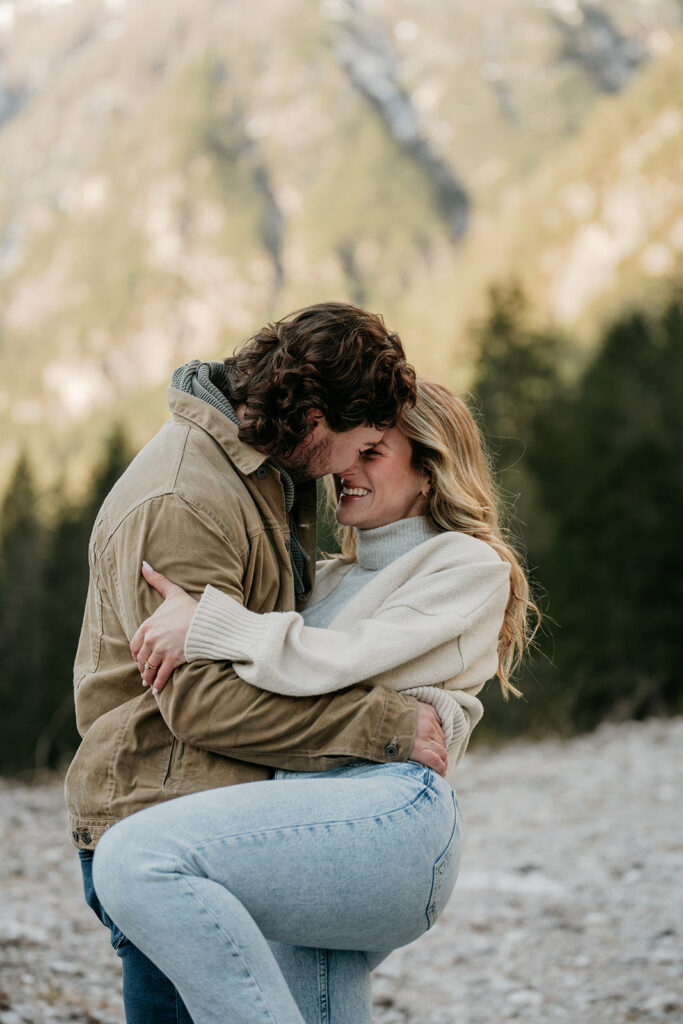 Couple embracing in outdoor setting, smiling warmly.