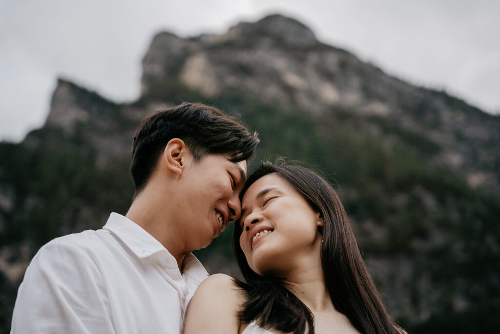 Couple smiling in front of mountain scenery.