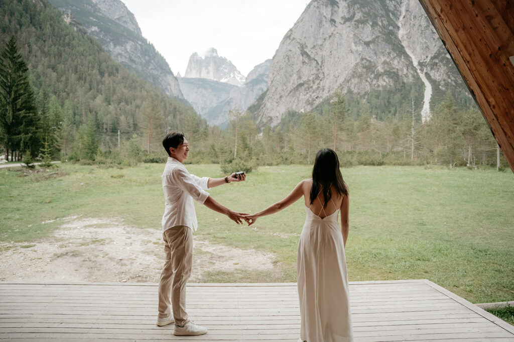 Couple holding hands in scenic mountain view.