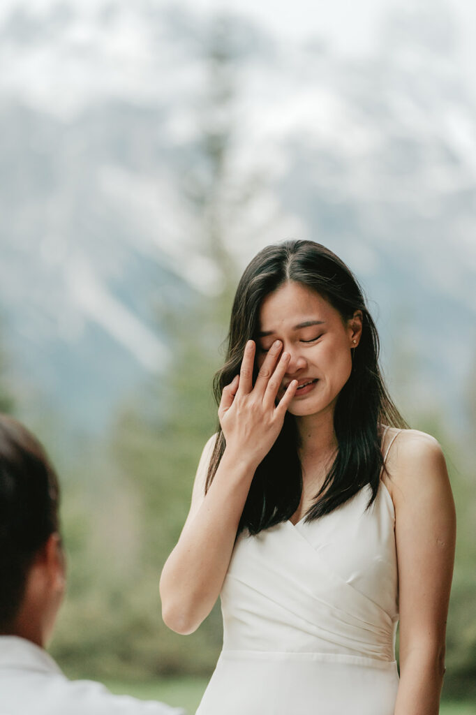 Emotional woman in white dress, outdoors.