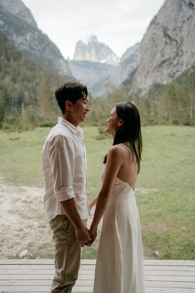 Couple holding hands in scenic mountain setting.