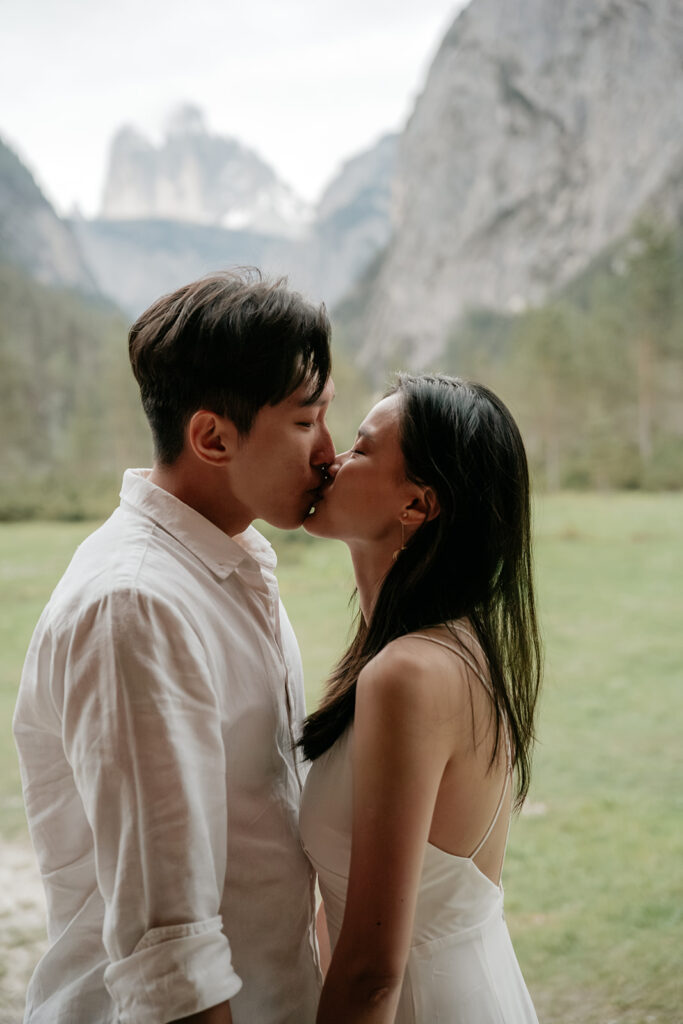 Couple kissing in scenic mountain landscape.