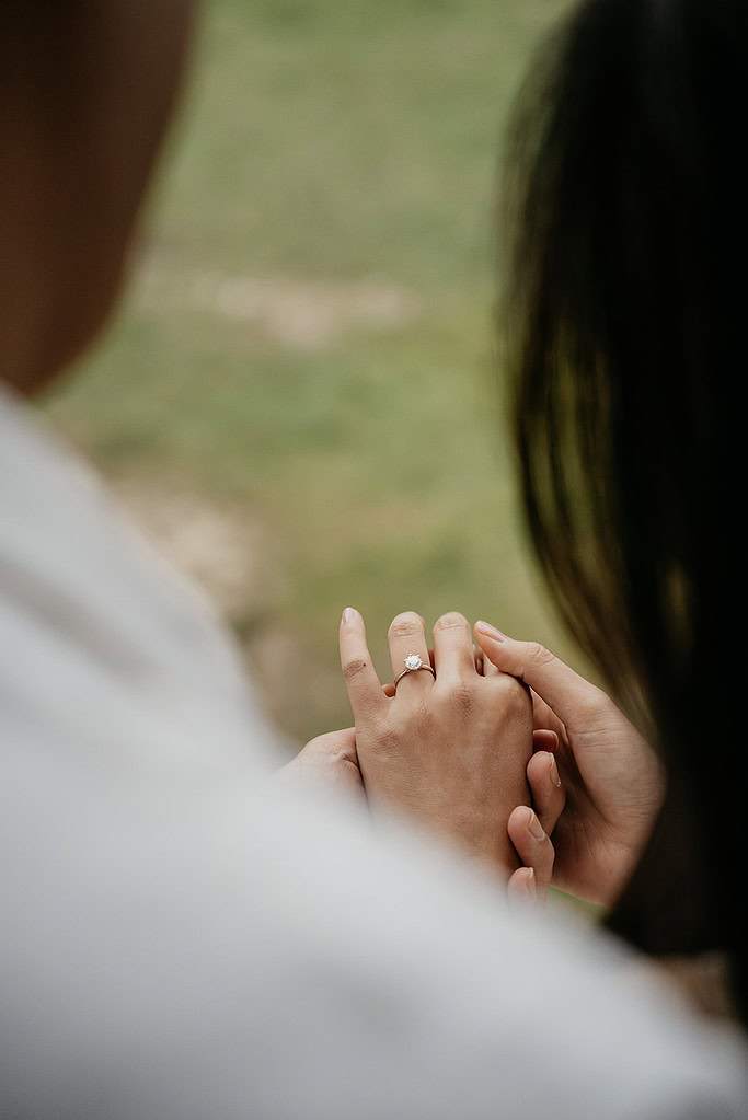 Close-up of hands with engagement ring.