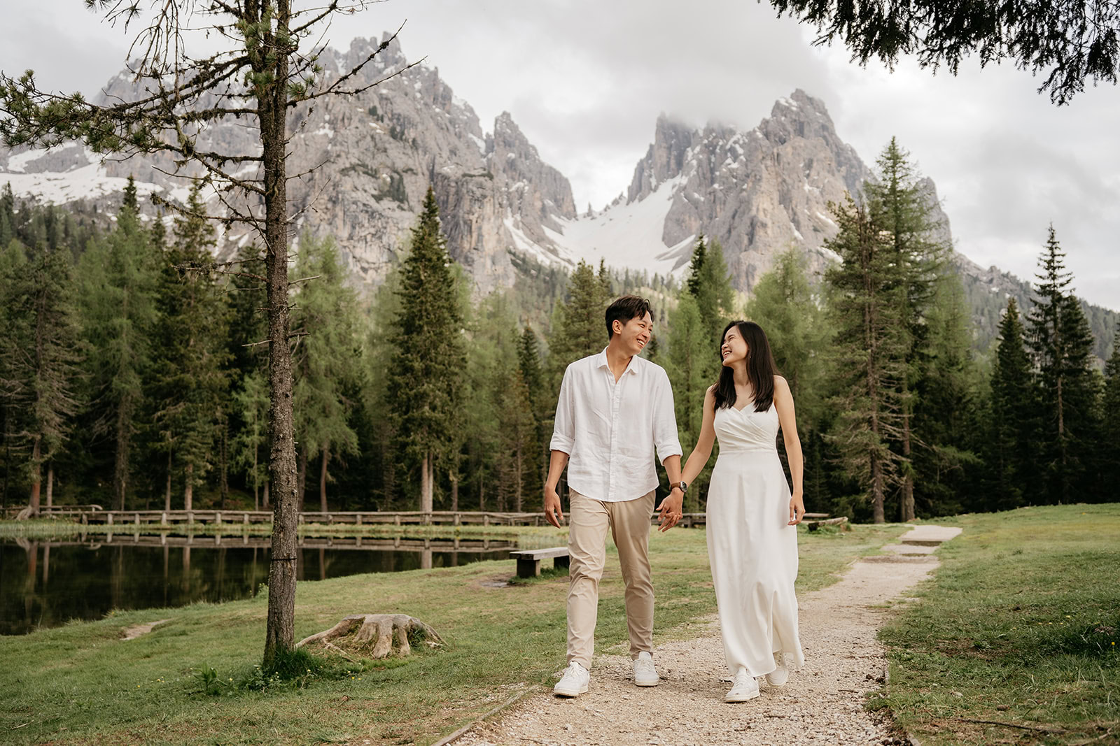 Couple walks in nature, mountains in background.