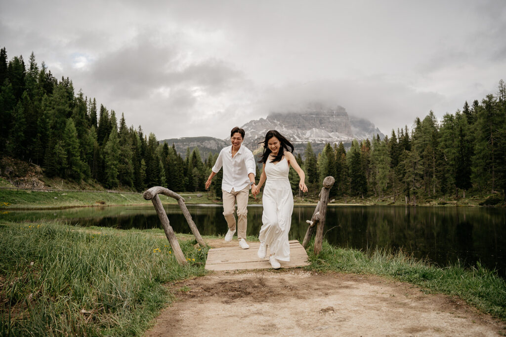 Couple running on bridge in scenic mountain forest