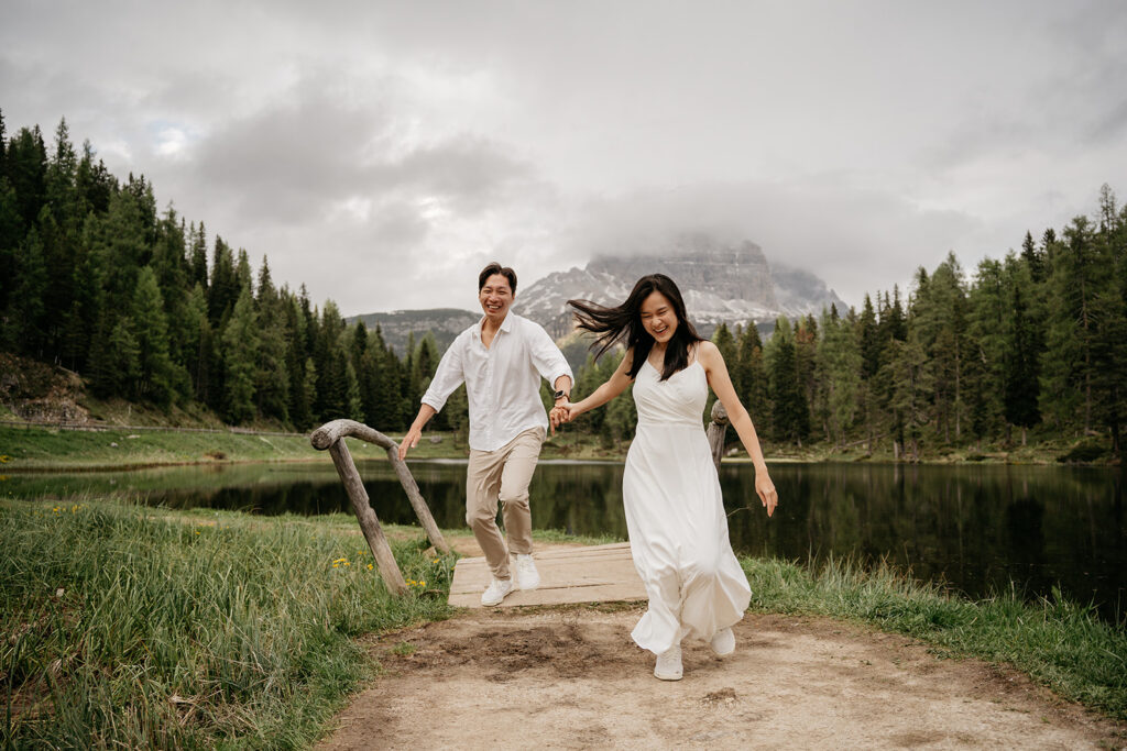 Couple holding hands, joyful in nature.