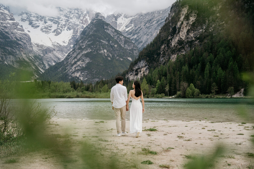 Couple holding hands by mountain lake