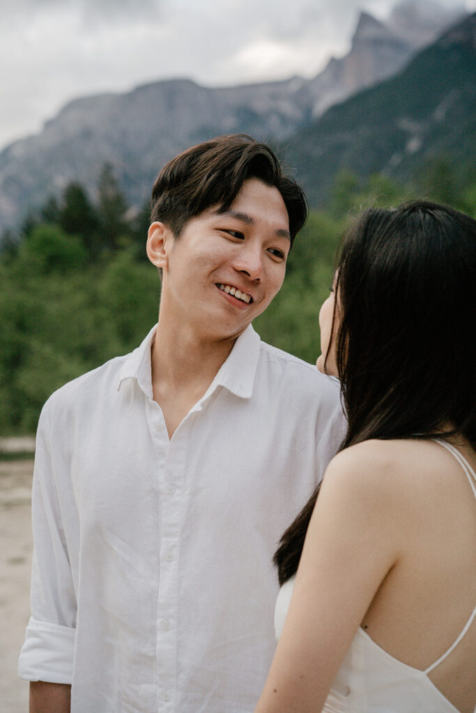 Couple smiling in front of mountain landscape.