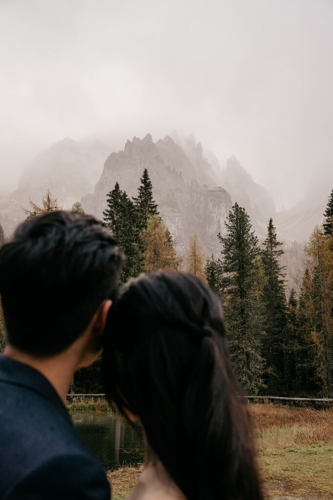 Couple embracing, misty mountain view.