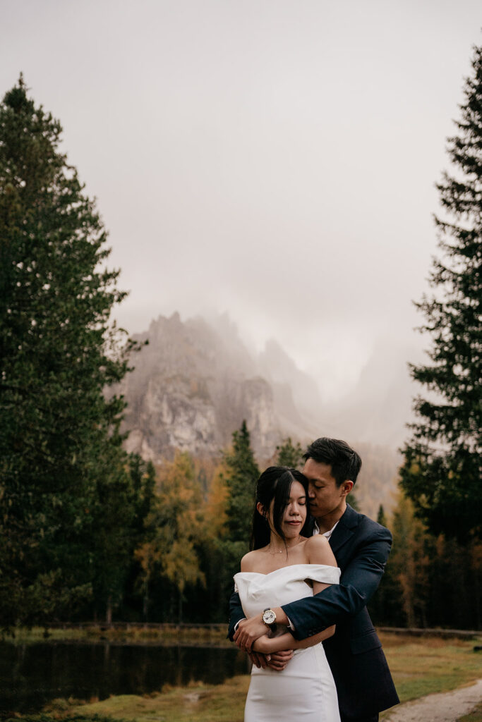 Couple embracing in scenic mountain landscape.