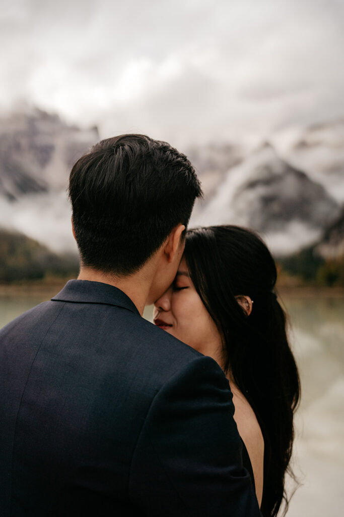 Couple embracing with mountain view in background.