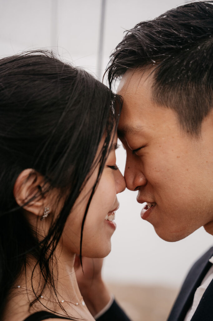 Close-up of couple smiling forehead-to-forehead.