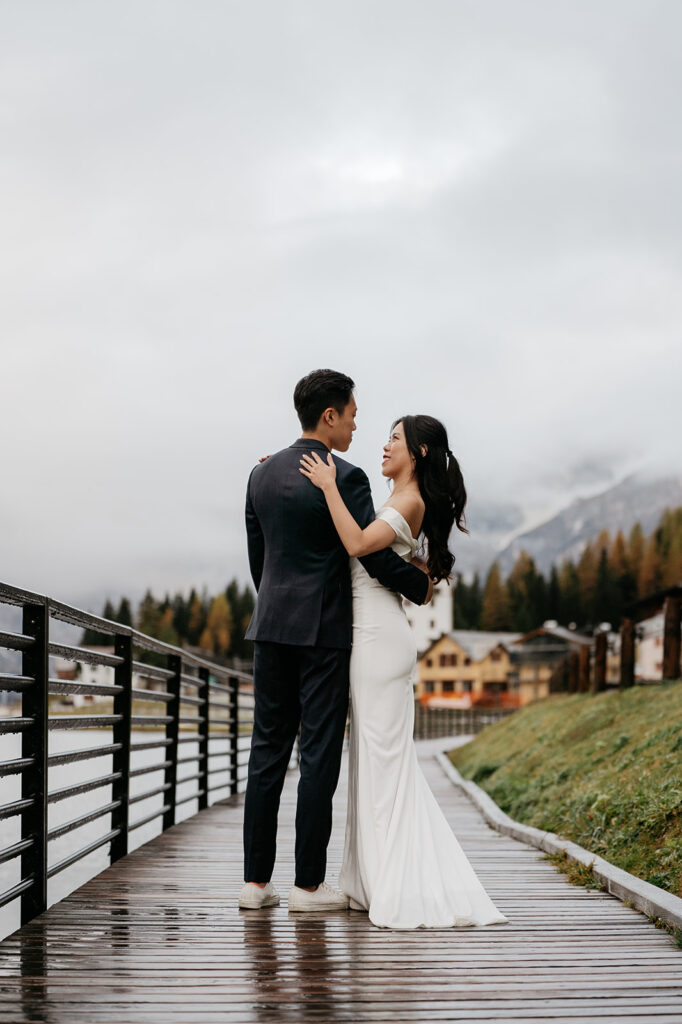 Couple embracing on wooden walkway.