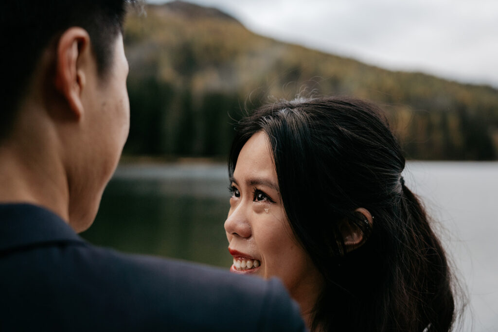 Woman smiling at man near scenic lake