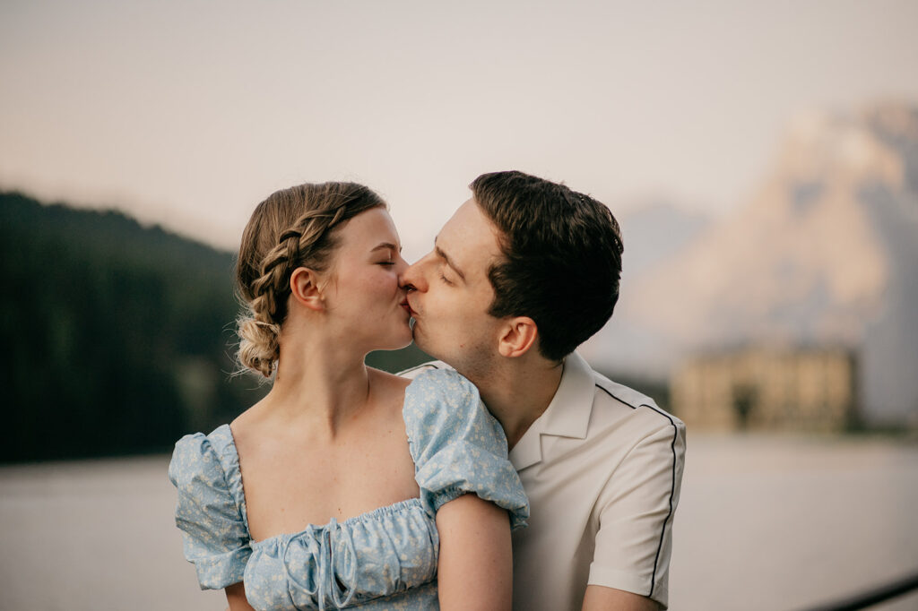 Couple kissing by a serene lakeside