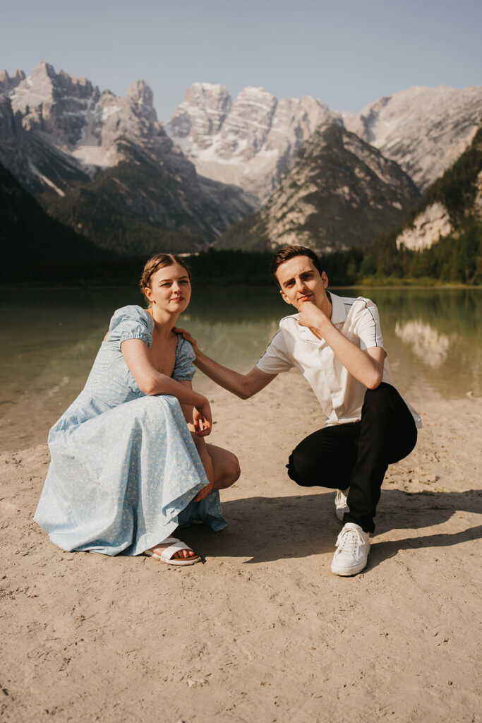 Couple posing by mountain lake.