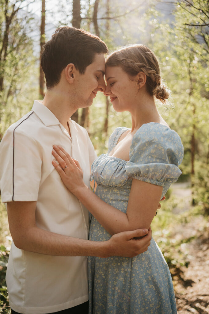 Couple embracing in a sunlit forest.