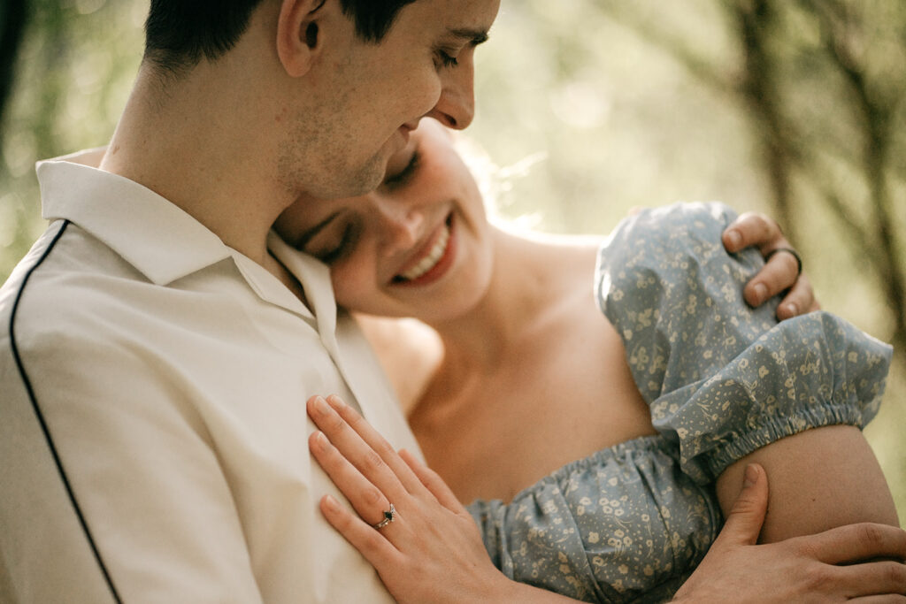 Couple embracing in sunny, outdoor setting.