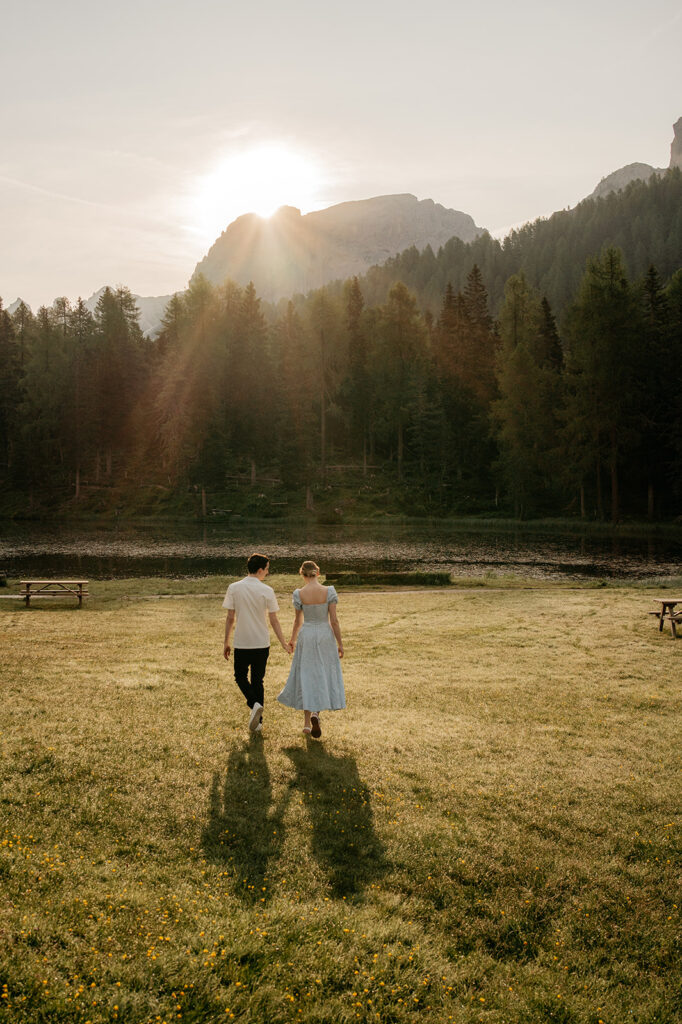 Couple walking in meadow at sunset