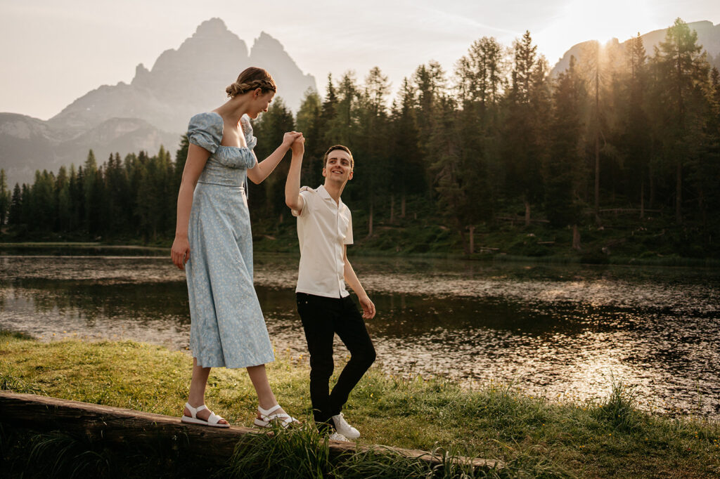 Couple walking by a scenic lake at sunset.