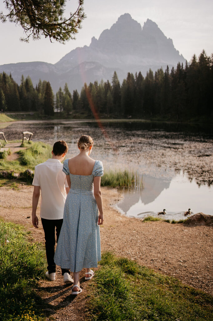 Couple walking near scenic lake and mountains